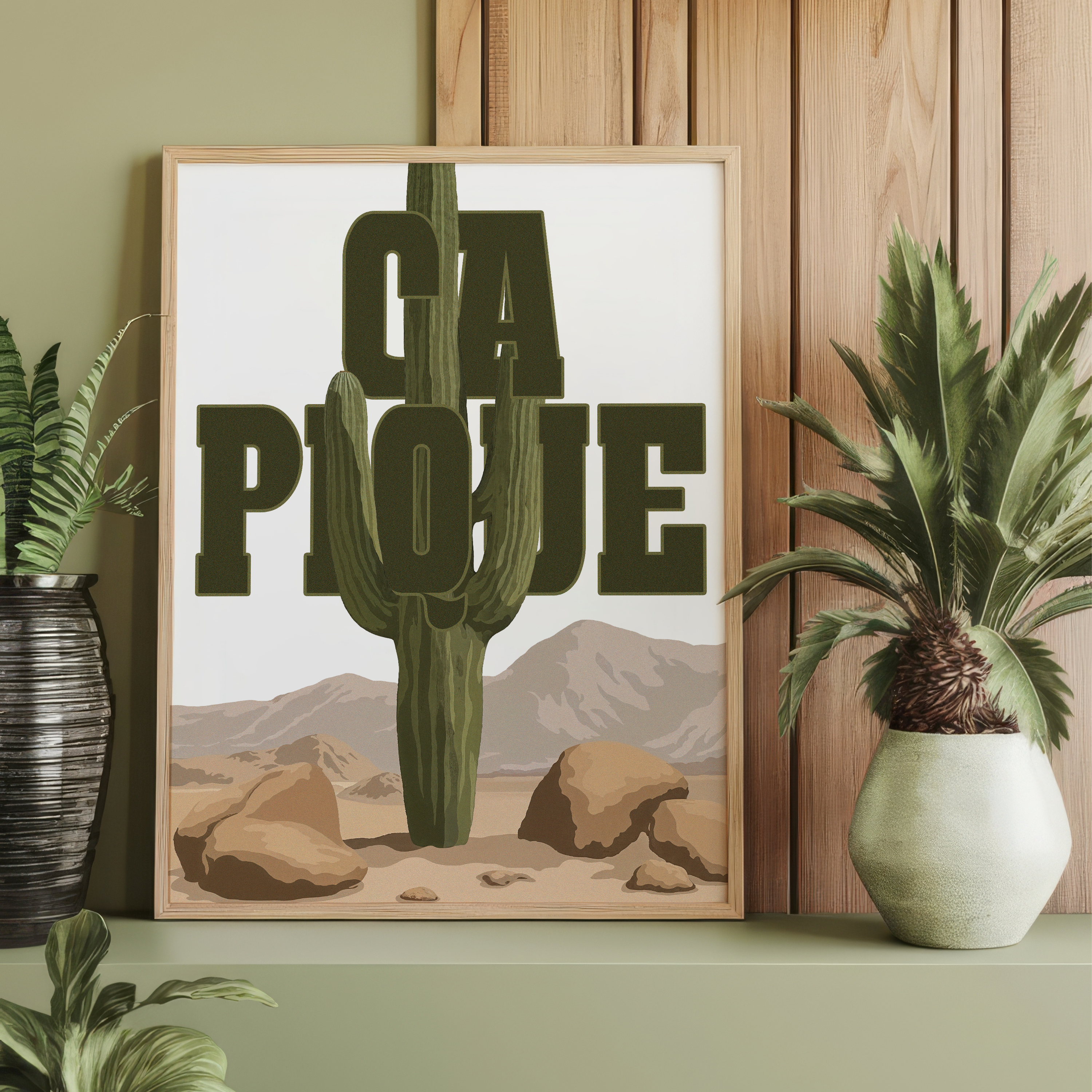 Affiche décorative humoristique "Ça pique" avec un grand cactus vert traversant une typographie imposante dans un paysage désertique avec montagnes et rochers, style graphique vintage, idéale pour une décoration murale originale et décalée.