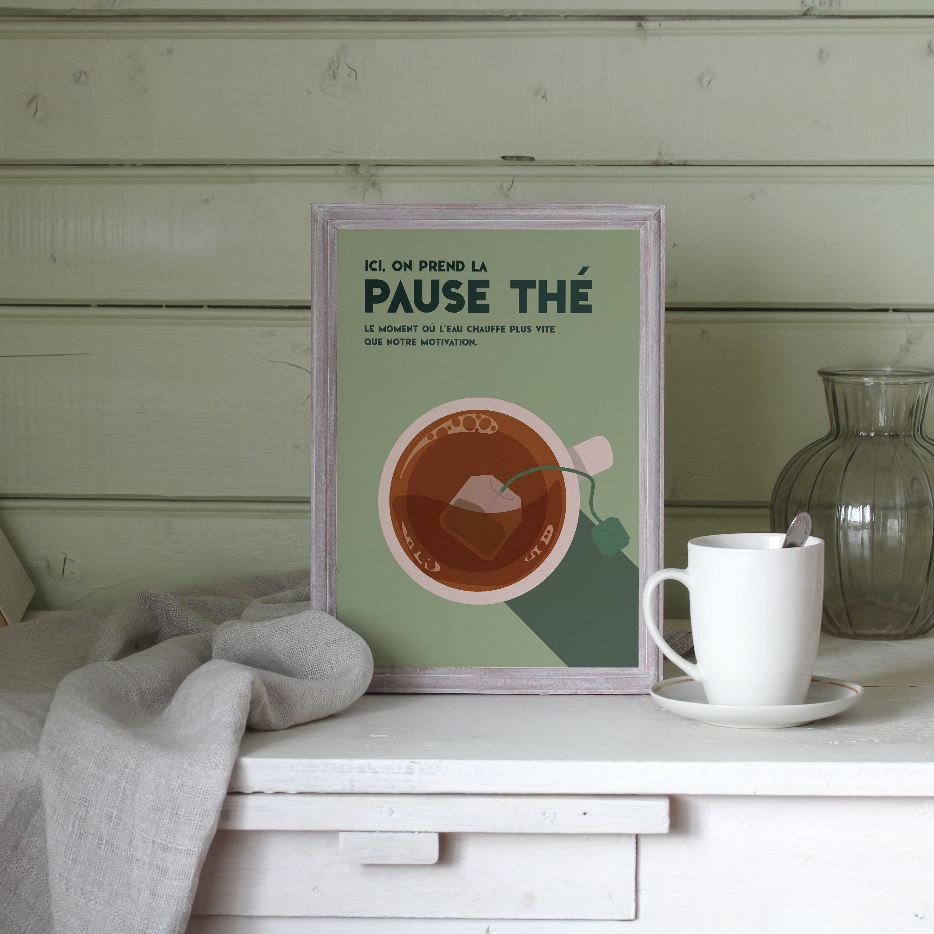 Affiche déco humour pause thé, tasse de thé vue du dessus avec sachet, fond vert, cadre bois, texte “Ici, on prend la pause thé – Le moment où l’eau chauffe plus vite que notre motivation”, illustration minimaliste style vintage, idéale cuisine ou bureau.